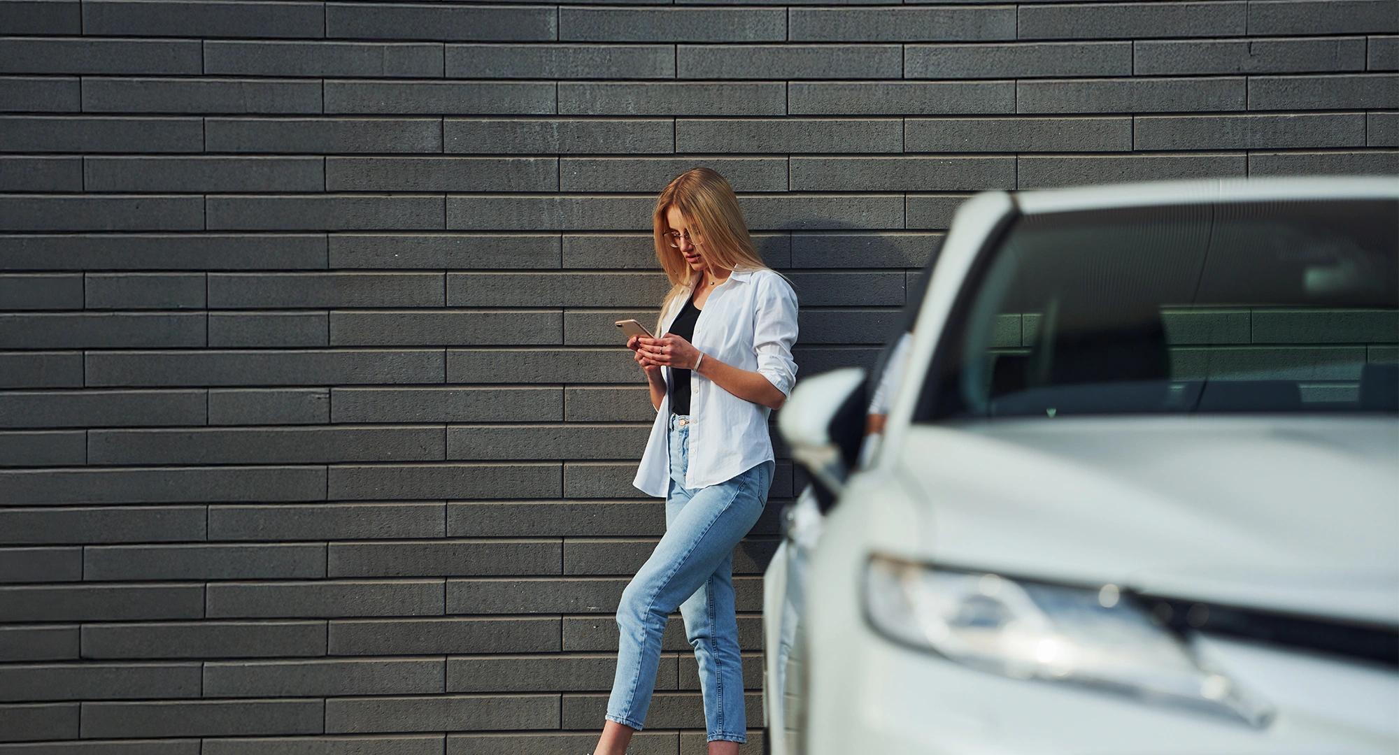 Woman using cashless parking from Zapper on her phone in a car parking lot