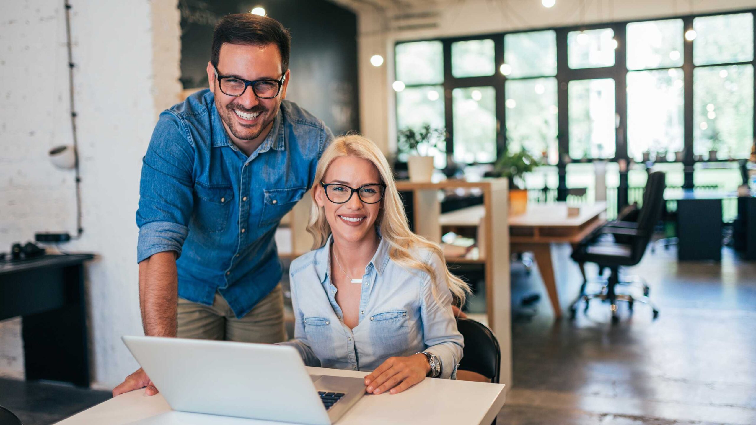 A man and woman smiling over a laptop after getting Zapper business funding